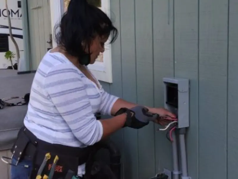 Licensed electrician wiring an exterior subpanel in Rainbow City